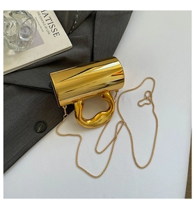 Close-up of luxury gold metallic handbag with artistic lava handle and chain strap