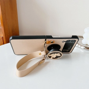 Detail of leather folding case with beige strap and gold bear phone stand for Z Flip