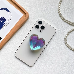 Macro shot of 3D iridescent heart-shaped phone grip attached to a white smartphone