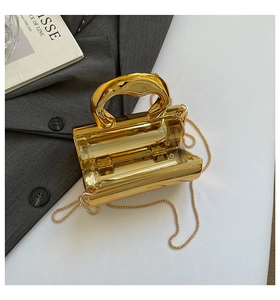 Detail of gold metallic clutch bag with mirror finish and interior hinge mechanism