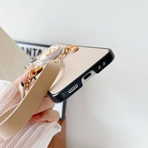 Detailed close-up of phone case with glitter texture, black frame and leather wrist strap