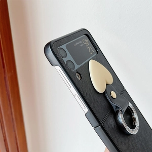 Detail of black textured leather case for Samsung Z Flip with heart charm and ring holder