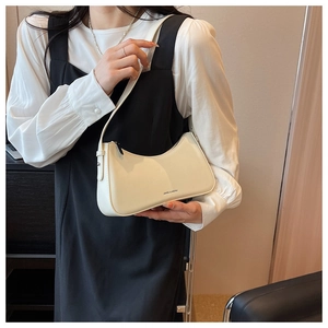 Detail view of cream hobo bag with smooth faux leather texture and minimalist logo