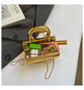 Detailed interior view of a shiny gold metallic handbag showing phone and cosmetic storage