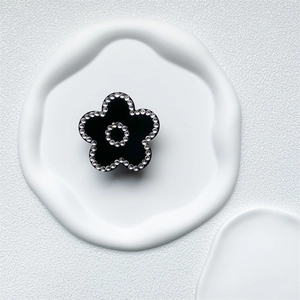 Detail of a luxury black floral phone grip with inlaid sparkling rhinestones