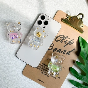 Detailed close-up of cute transparent bear phone grips with colorful glitters and sweet text