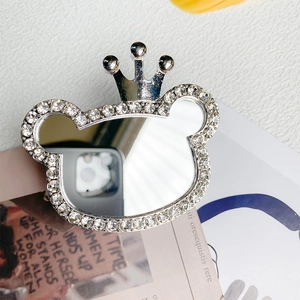 Macro view of a bear-shaped rhinestone phone grip with crown and built-in vanity mirror