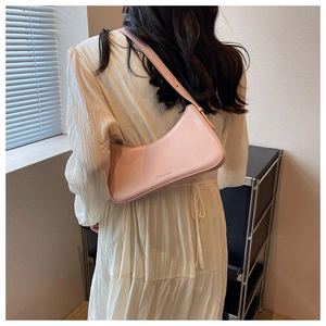 Detail of light pink hobo bag with adjustable strap and metal logo on smooth leather