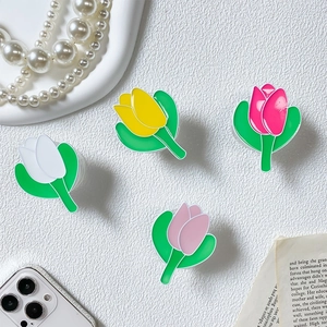 Detailed view of colorful tulip phone grips in white, yellow, and pink with a glossy finish