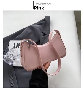 Detailed macro view of pink faux leather texture and metallic logo on chic shoulder bag