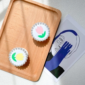 Détail de supports tulipe ronds avec bordure en perles sur plateau bois