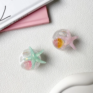 Detail of glitter starfish and seashell phone socket grips with a retractable stand
