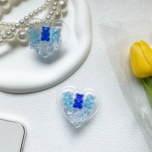 Detail of heart-shaped phone grip with blue gummy bears and clear resin ice texture