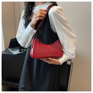 Detail of red glossy crescent shoulder bag with silver zipper and embossed logo