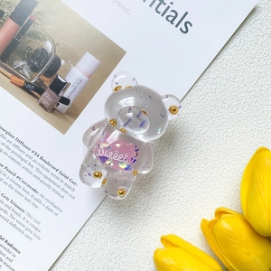 Close-up of bear-shaped phone grip with purple glitter and 'Sweet' text on magazine