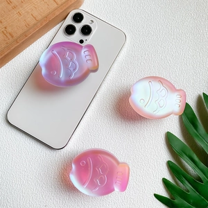 Detailed view of 3D laser fish-shaped expandable phone grips on a white iPhone