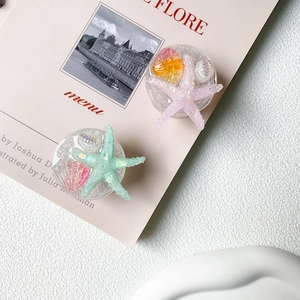Sparkly ocean shell and starfish collapsible phone grip stand in pink and green
