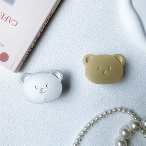 Detail of cute bear-shaped retractable phone holders in matte silver and champagne gold