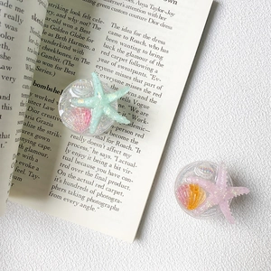 Detail of glitter starfish and seashell phone socket grip with transparent base