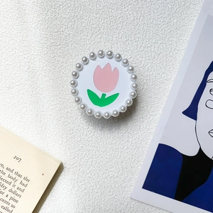 Gros plan d'un support de téléphone tulipe rose avec bordure en perles blanches