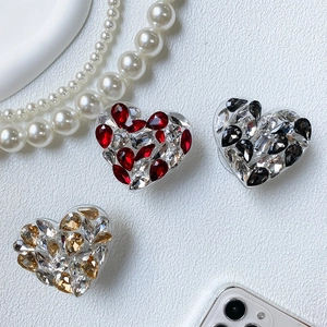 Detailed view of luxury heart phone grips with sparkling rhinestones in three colors