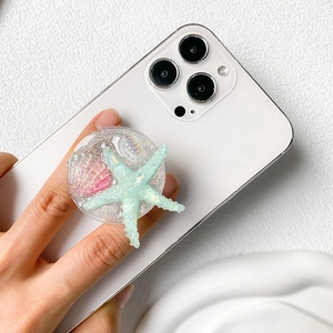 Summer ocean shell and starfish phone pop socket with glitter finish on a white smartphone