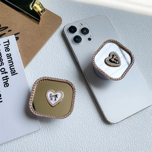 Detailed view of luxury square rhinestone phone grip with mirror and heart bow design