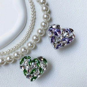 Detail of luxury rhinestone heart phone grip with sparkling crystals on white leather