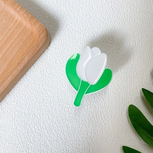 Close-up of white tulip phone grip with green leaves on a clean textured background