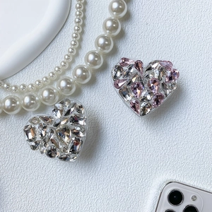 Detailed view of luxury heart-shaped phone grips with sparkling rhinestones and clear base