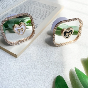 Detail of luxury heart phone grip with rhinestones, pearls and golden bow decoration