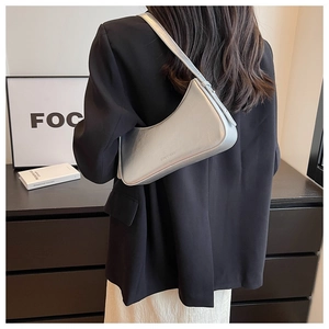 Silver metallic leather hobo bag styled on shoulder with a sleek black blazer
