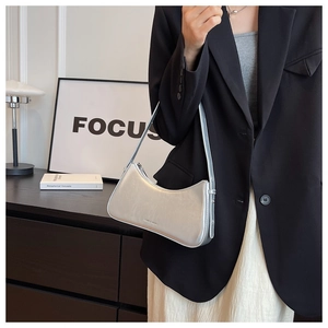 Silver metallic baguette bag with smooth curved top and sleek zipper detail