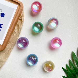Iridescent aurora crystal balls set with glitter inside on white textured surface