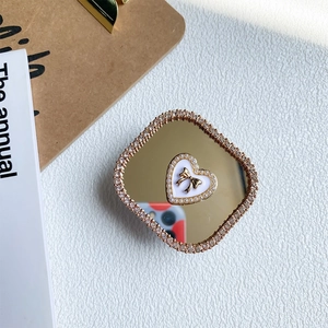 Close-up of luxury heart phone grip with sparkling rhinestones and a gold mirror finish