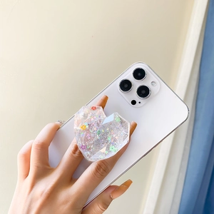 Detail of heart shaped phone socket with colorful sequins and pearls on white base