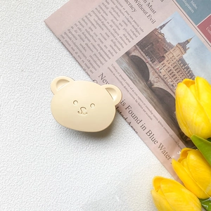 Close-up of cute cream bear phone socket grip on a soft aesthetic background