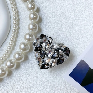 Close-up of heart-shaped phone grip with luxury black and clear rhinestones