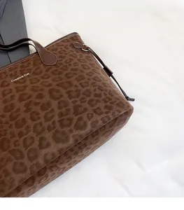Detail of leopard print tote bag with Creative Cat logo and dark brown leather straps