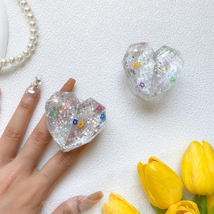 Close-up of heart resin phone grip with silver glitter, colorful sequins and pearl inlay