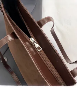 Close-up of the silver metal zipper and hardware on the brown leopard tote bag