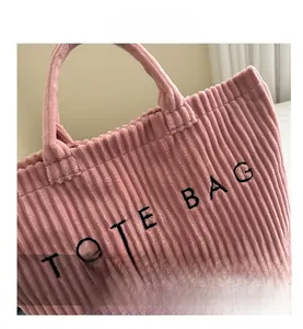 Close-up of pink corduroy tote bag featuring premium embroidered texture and soft handles