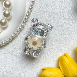 Detail der glitzernden Bären-Handyhalterung mit cremefarbener Blume und Silber-Pailletten