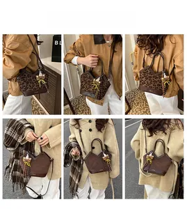 Detail of leopard print crossbody bag featuring JSN logo and cute bear pendant accessory