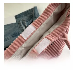 Detail view of the pink corduroy tote bag showing the white Velcro closure and grey lining