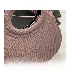 Vue détaillée de la texture rose pailletée et des coutures de ce sac à main demi-lune