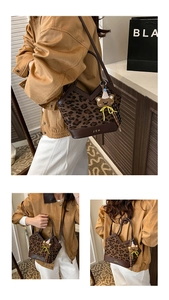 Detail of leopard print bucket bag with bear charm and gold J S H lettering on front