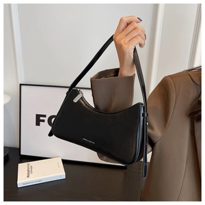 Detail of classic black baguette bag with silver metallic logo and sleek shoulder strap