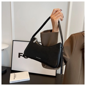Close-up of black leather hobo shoulder bag with white lettering and silver zipper