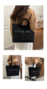 Detailed macro view of black corduroy fabric texture and white TOTE BAG embroidery